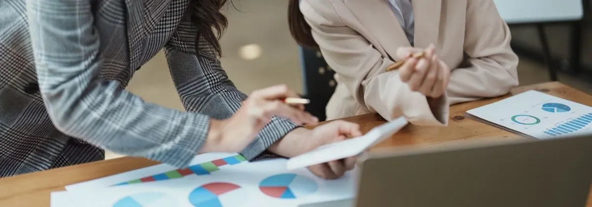 Hands, a tablet and printed charts during a working session