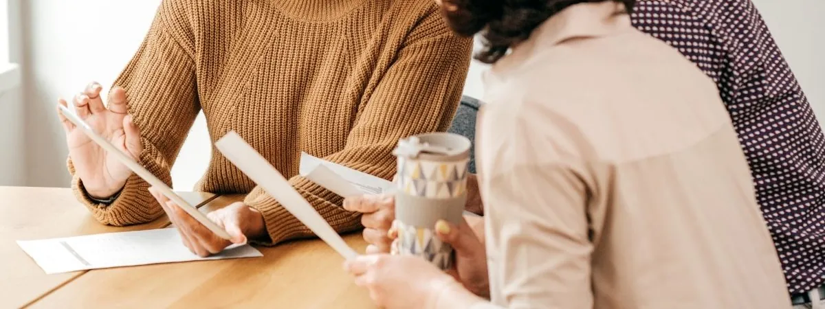 Colleagues working through printed reports around a table
